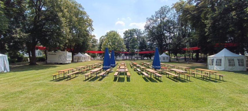 Pavillons mit Seitenwänden und Dach sowie Bierzeltgarnituren auf der Wiese im Usinger Schlossgarten beim Familienfest