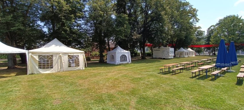 Pavillons mit Seitenwänden und Dach sowie Bierzeltgarnituren auf der Wiese im Usinger Schlossgarten beim Familienfest